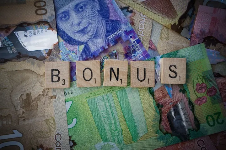 scrabble blocks spelling "bonus" on top of money