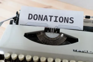 typewriter with paper. paper says "donations"