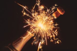 champagne bottle popping open with a firework inside