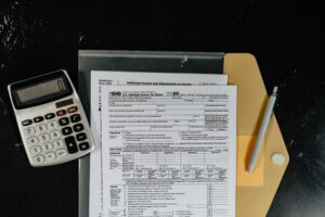 a calculator, pen and tax forms